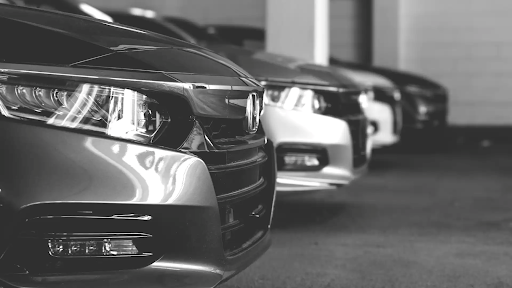 Buying new vs used car – Used cars lined up at a dealership