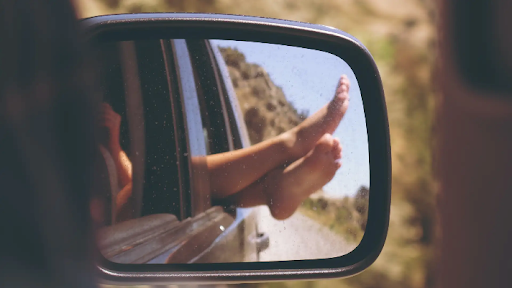 What is vehicle insurance – Wing mirror showing the reflection of a passenger’s feet out of the window