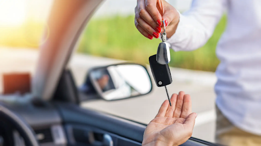 How to purchase a new car – A man handing the keys to a new car over