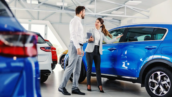 What to ask a car dealer - A car dealer showing a car to a customer