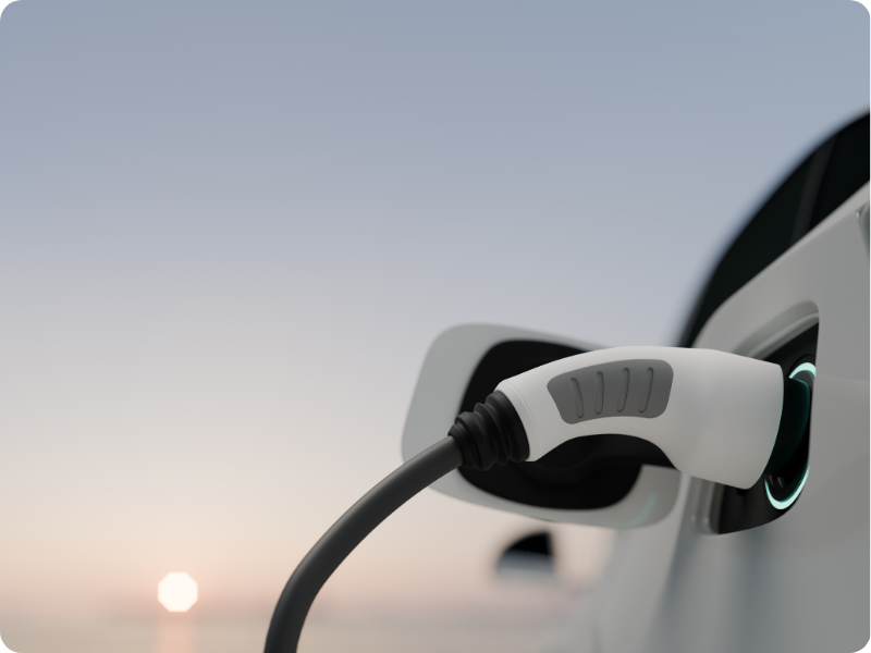 Want to know everything about ev road user charges in NZ - read this. EV charging with the setting sun behind it