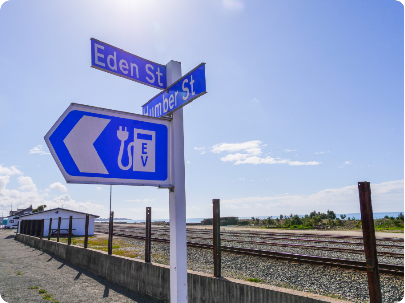 Electric vehicle road user charges - everything you need to know (NZ road with EV charging road sign)
