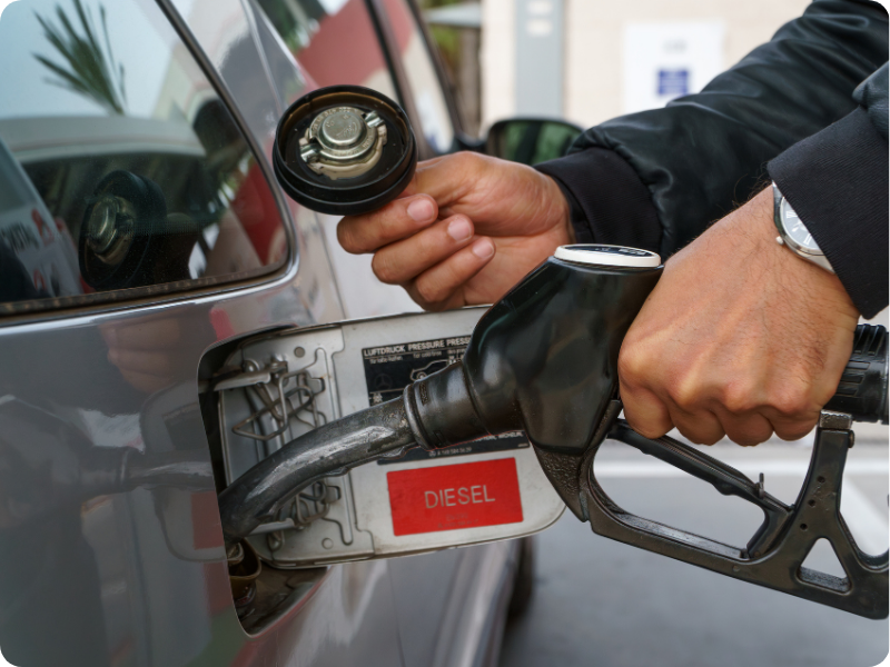 Everything you need to know about diesel road user charges before you get to the pump (hand filling up a diesel car at a gas station)
