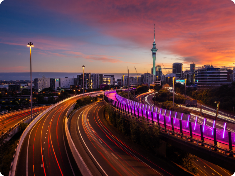 If you're moving to NZ and looking to buy a car as a foreigner, these are the kinds of views you could see every day. Long exposure image of vehicles driving into Auckland city and sunset